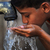 A Pakistani child drinks water from a ha
