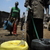 A water-vendor collects water in jerryca