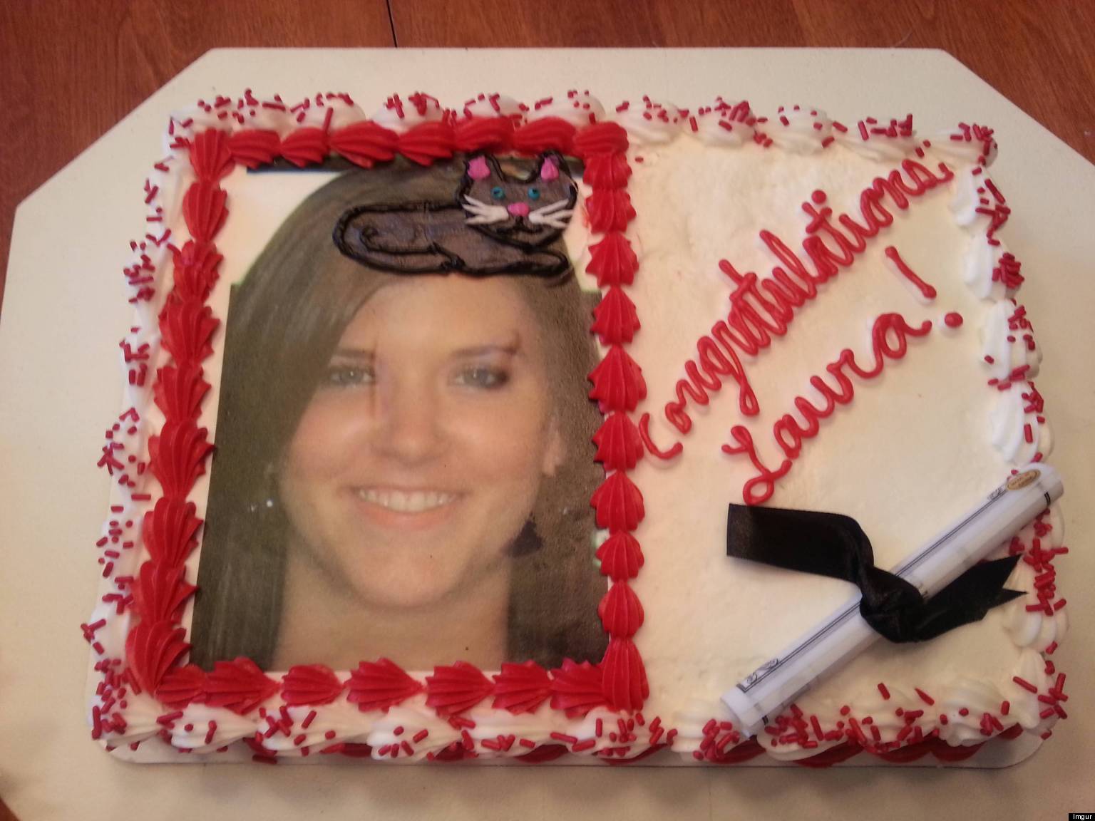 a photo of a cake with a womans smiling face on it. there is a cat on the op of her head