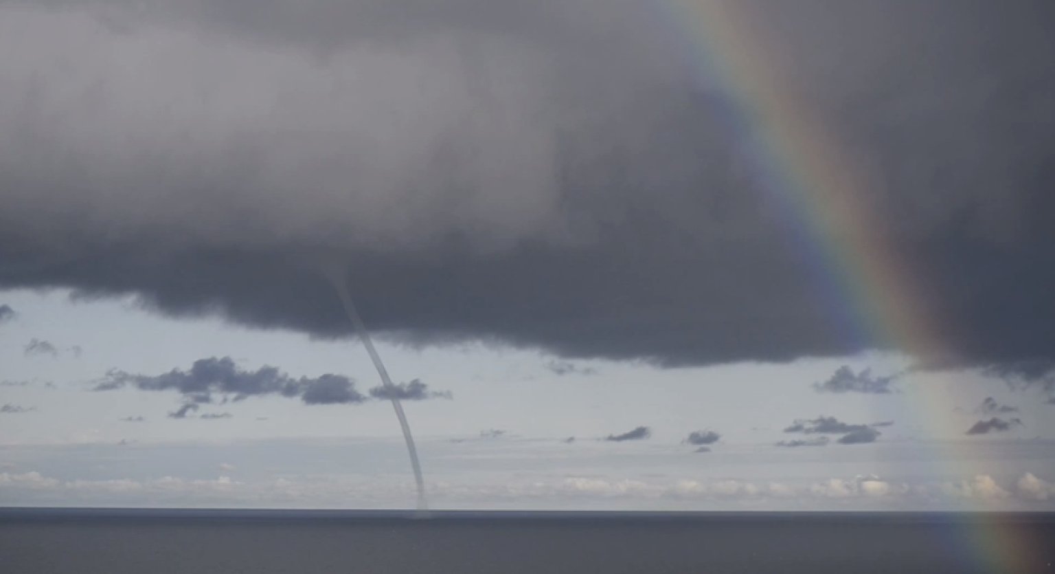 rainbow-and-waterspout-over-baltic-sea-make-quite-the-odd-couple-video