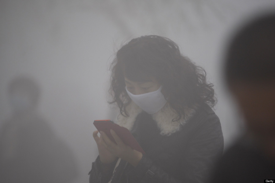 woman wearing a mask uses her mobile phone
