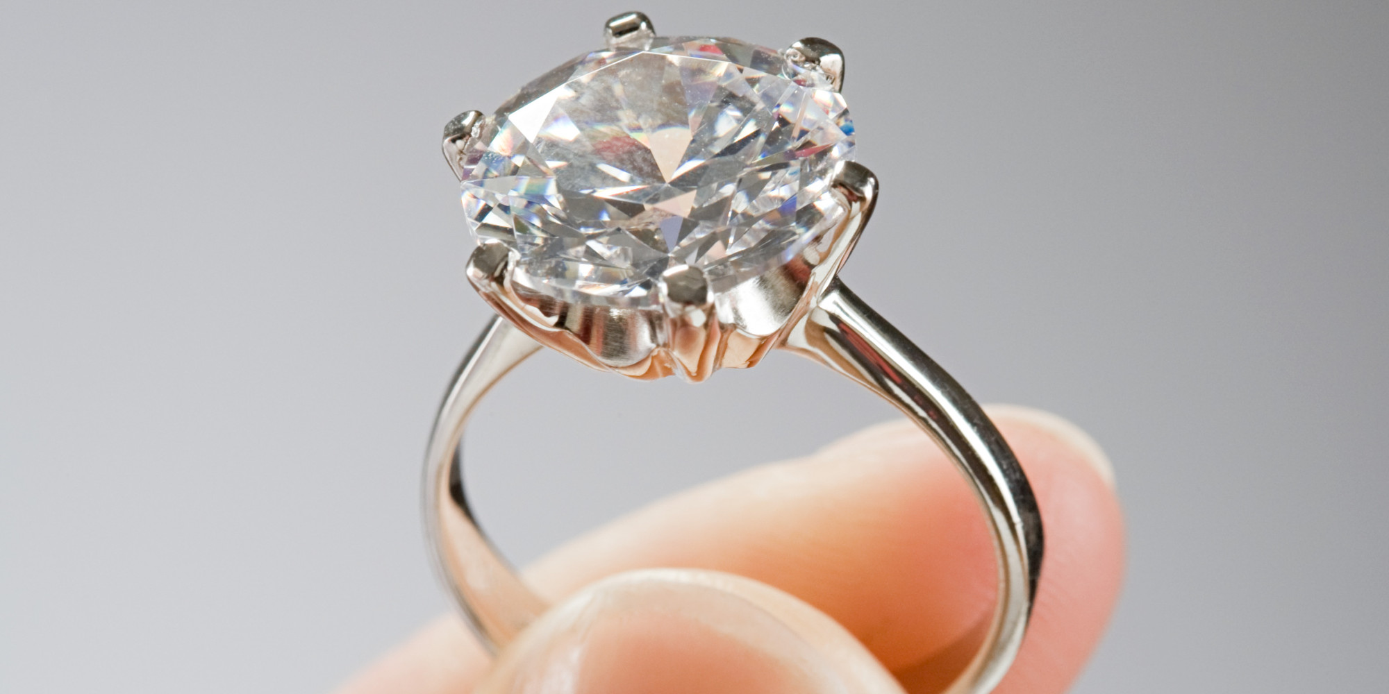 Woman gives engagement ring to couple