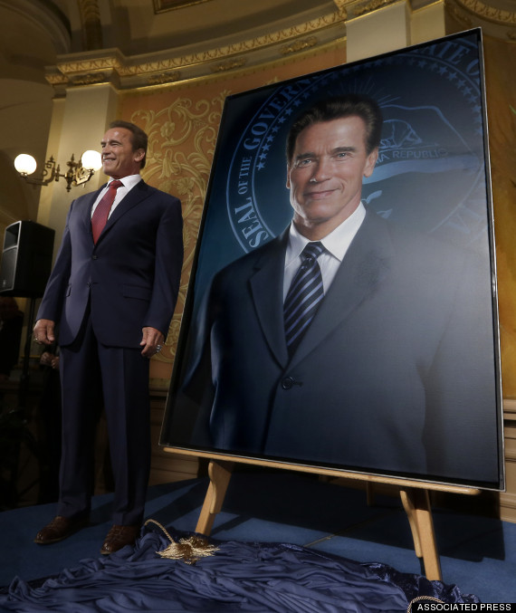 Arnold Schwarzenegger posing with his portrait