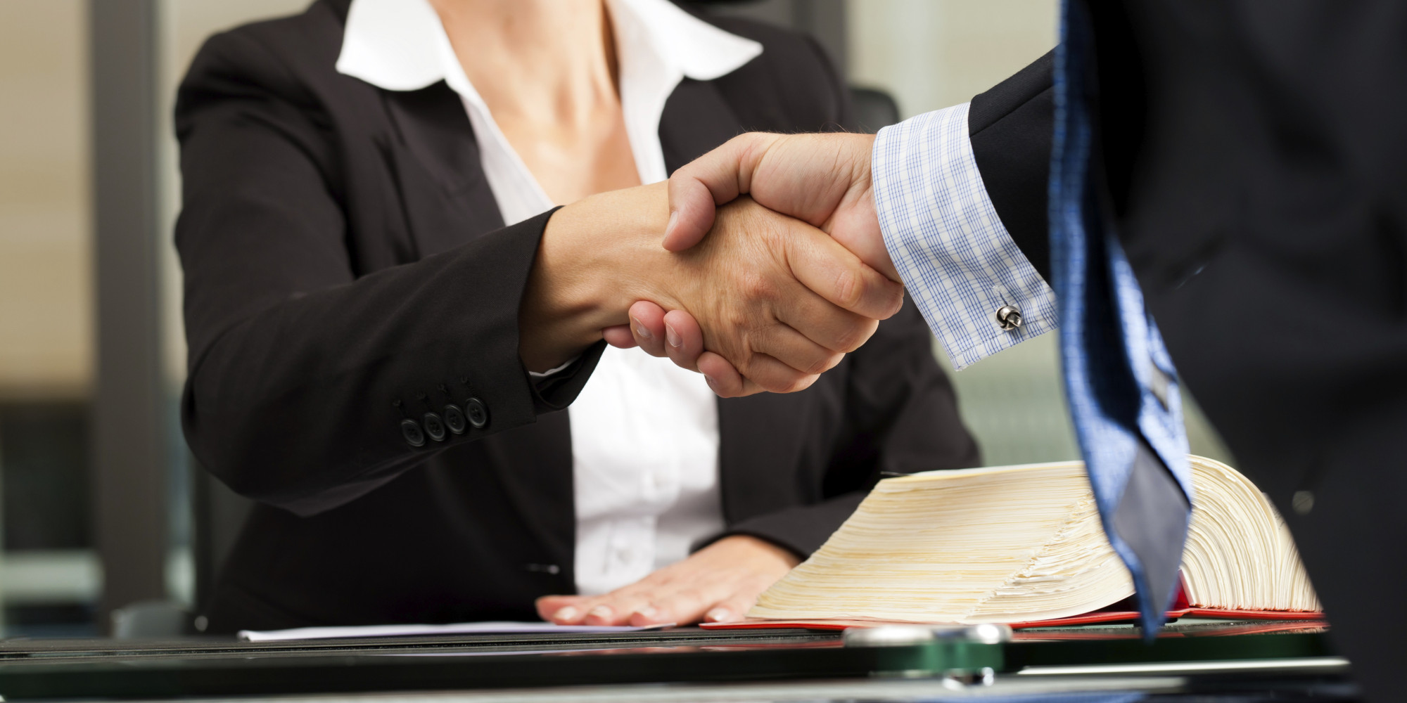  A male client shakes hands with his female attorney in her office during divorce proceedings.