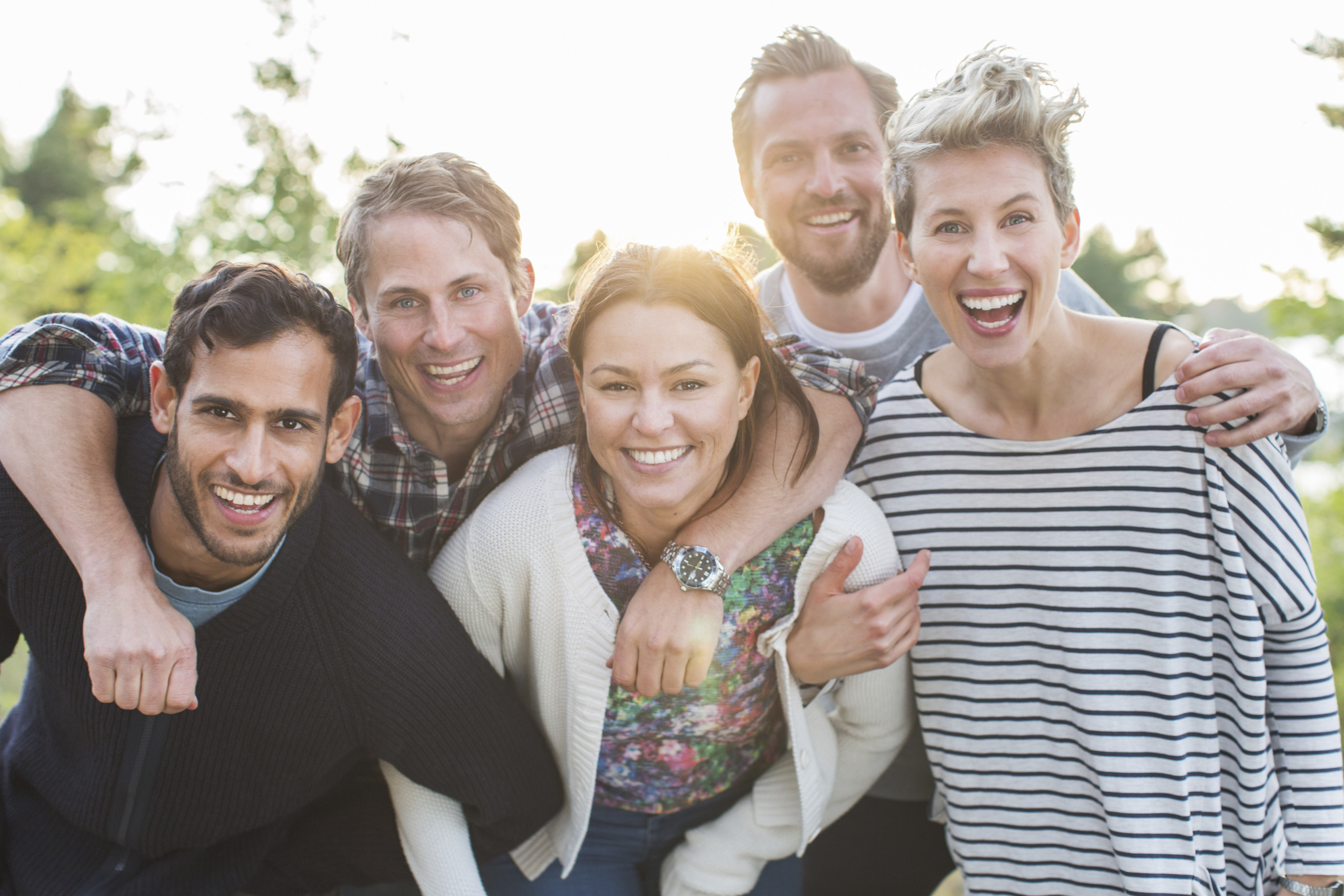 group portrait of happy friends enjoying picnic at