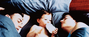kid sleeping in bed with parents