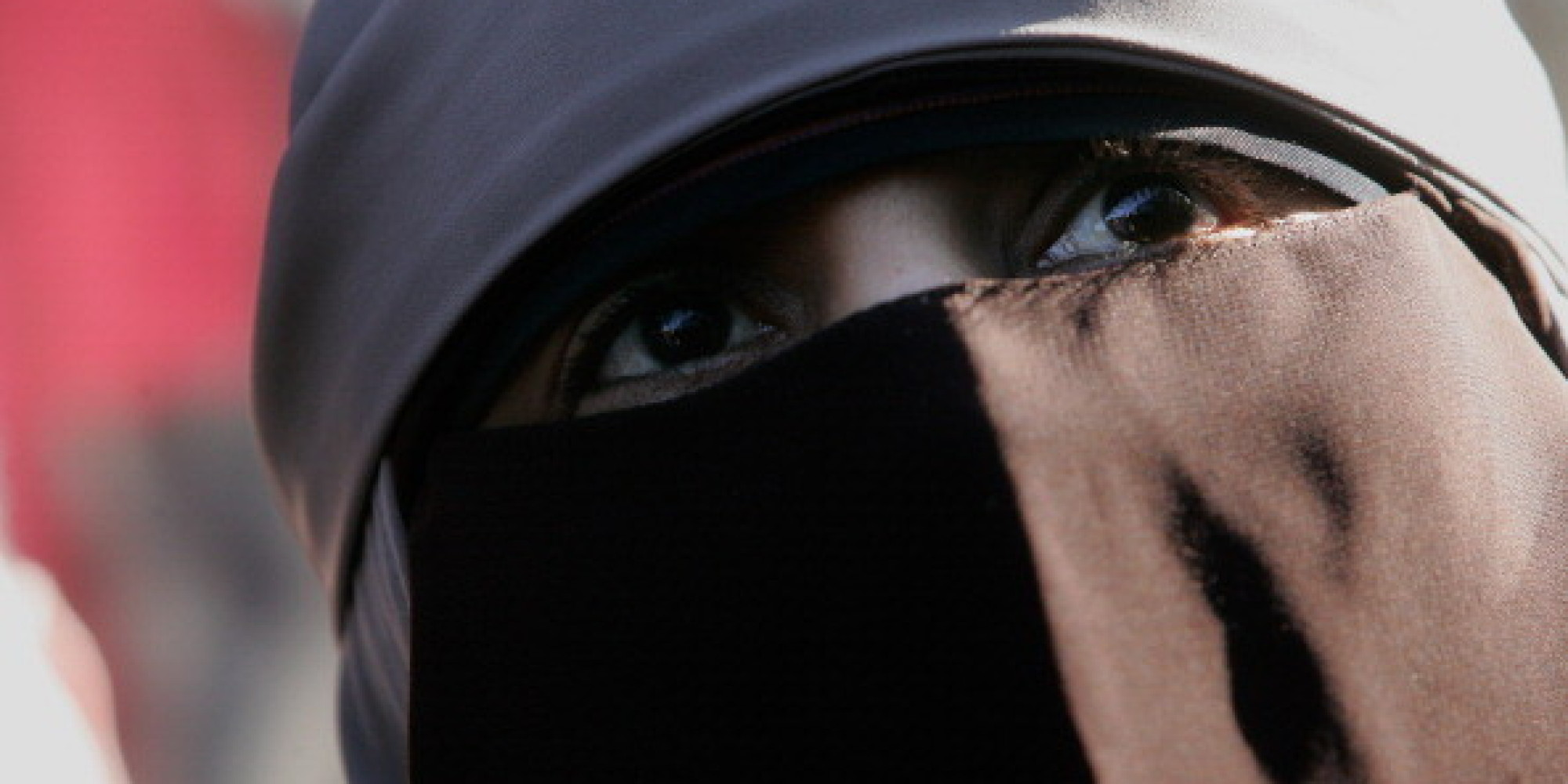 Eine Frau mit Burka und Kinderwagen steigt in Frankfurt in den Bus