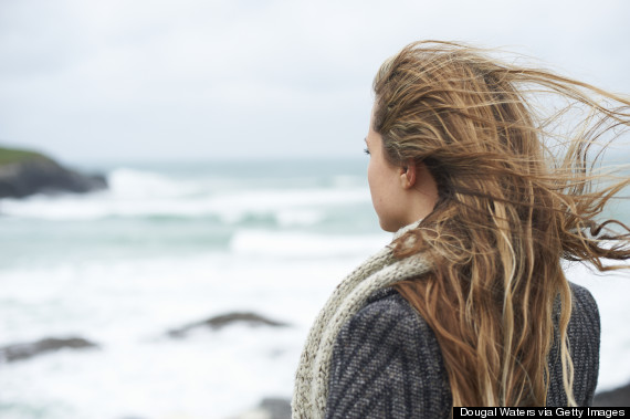 woman alone looking at ocean rear