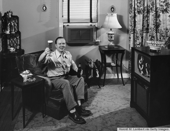 man in armchair watching television