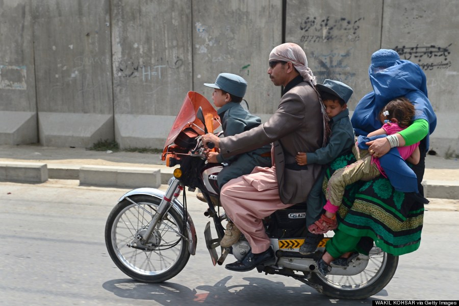 an afghan family travelling by motorcycle in kabul