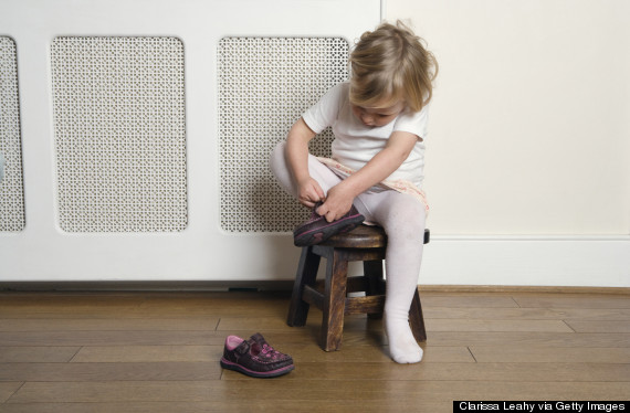 kid putting shoes on