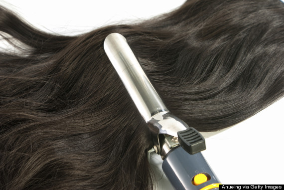 woman curling hair with curling iron