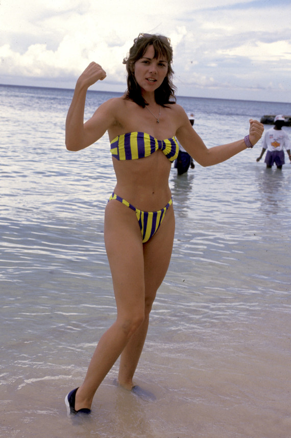 Med henne tunn kropp och Medel blond hårtyp utan behå (kupstorlek 34B) på stranden i bikini
